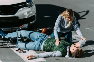 Person laying on the floor after being hit by a car while riding his bike,