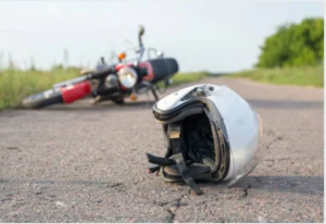 A motorcycle laying on it's side, in back round and helmet