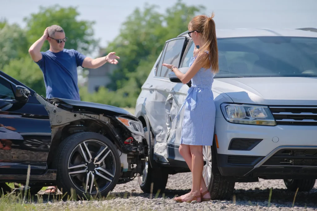 Two motorists standing by their vehicles after an accident.